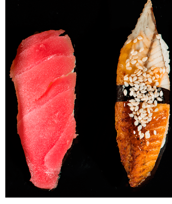 Duas peças de sushi em um fundo preto: uma com atum cru rosa brilhante e a outra com enguia grelhada coberta com sementes de gergelim e uma tira de alga marinha.